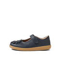 A single Bobux Iwalk Pixie Toddlers Mary Jane Navy Leather 652502 shoe with a tan rubber sole, Velcro strap, and decorative flower on the toe. "BOBUX" is embossed on the side of the sole.