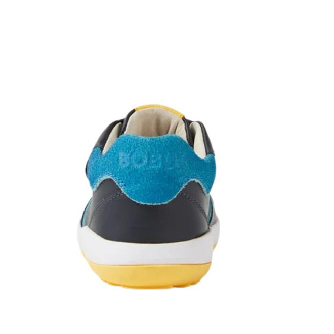 Rear view of the Bobux IW Iwalk Baseline Leather Mid Sneaker Navy, featuring kids' leather with a blue suede heel panel, dark upper, white midsole, and yellow outsole, photographed against a plain white background., 9420074818560, 9420074818577, 9420074818584, 9420074818591