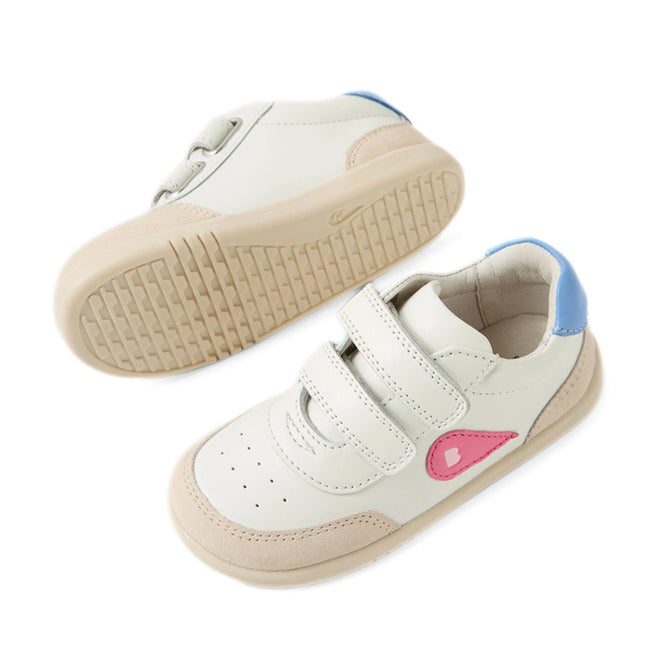 Two Bobux IW Iwalk Toddlers Champ Leather Sneakers in white and pink leather, featuring beige accents, hook-and-loop straps, blue heel details, and a pink heart-shaped embellishment on the side. One shoe stands upright while the other displays its textured sole., 9420074856654, 9420074856661, 9420074856678, 9420074856685, 9420074856692