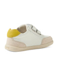 The Bobux IW Iwalk Toddlers Champ Leather Sneaker in White Green is a stylish children’s leather shoe featuring white uppers with beige suede accents, a yellow heel detail, two hook-and-loop straps for easy fastening, and a light tan rubber sole. It is pictured from an angled rear view., 9420074856609, 9420074856616, 9420074856623, 9420074856630, 9420074856647