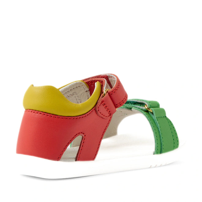 Introducing the Bobux IWalk Dune Toddlers Sandal Grenadine Red Open Toe—a vibrant and adventure-ready sandal for kids, showcasing red, green, and yellow leather straps with a white sole and adjustable closures. Shown from the back angle, these comfortable leather sandals are perfect for little explorers., 9420074855091, 9420074855107, 9420074855114, 9420074855121, 9420074855138