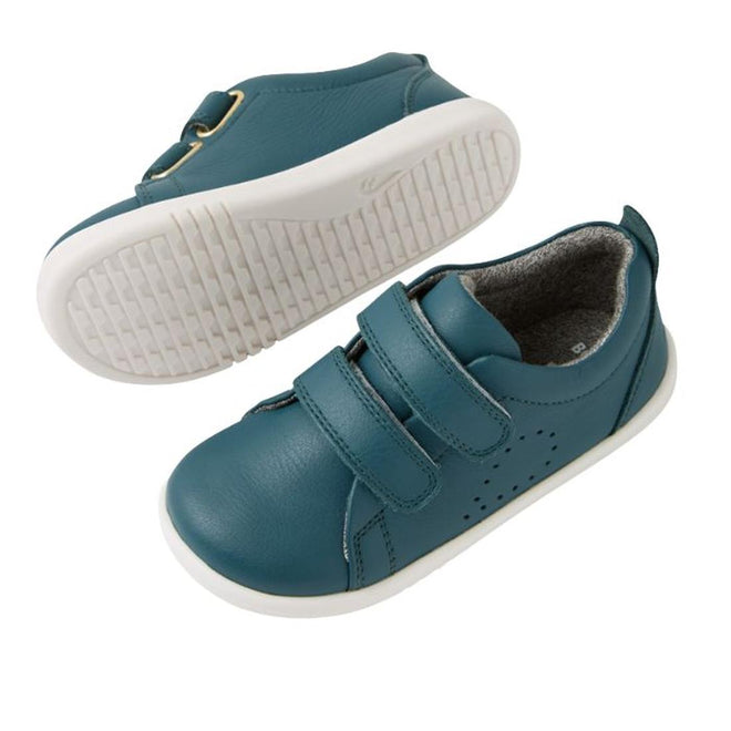 The Bobux IW Iwalk Grass Court Leather Sneaker in Mediterranean Green for toddlers features a premium leather upper, perforated sides, white soles, and two Velcro straps. One shoe is upright; the other displays its sole., 9420074806734, 9420074806741, 9420074806758, 9420074806765, 9420074806772