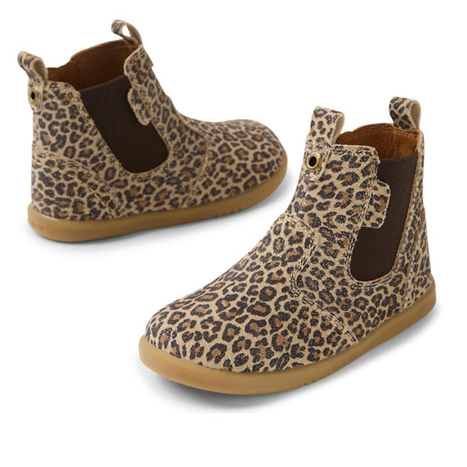 The Bobux IW Iwalk Jodhpur Leather Boot Leopard Shimmer features a tan and brown leopard print, elastic side panels, and light brown rubber soles, blending playful style with everyday comfort for toddlers.