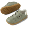 The Bobux IW Iwalk Maverick Leather Sneaker in Vetiver Green features kids' leather uppers, tan rubber soles, white heel detail, perforated sides for breathability, and double adjustable straps. One shoe is shown side-on; the other displays the textured sole., 9420074836427, 9420074836434, 9420074836441, 9420074836458, 9420074836465