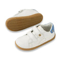 The Bobux IW Iwalk Maverick Leather Sneaker in White and Coronet Blue features white leather, tan rubber soles, blue heel accents, and two velcro straps. Displayed on a white background; one shoe is upright while the other shows the sole., 9420074836588, 9420074836595, 9420074836601, 9420074836618