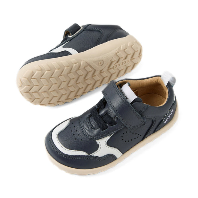 A pair of Bobux IW Iwalk Neo Toddlers Leather Sneaker Navy Barefoot are shown: both sneakers feature navy blue and white leather uppers with beige soles. One shoe is upright, highlighting its top and side, while the other is flipped to display the tread pattern beneath. Designed as barefoot shoes, they have a zero drop sole to support healthy foot development., 9420074854759, 9420074854766, 9420074854773, 9420074854780