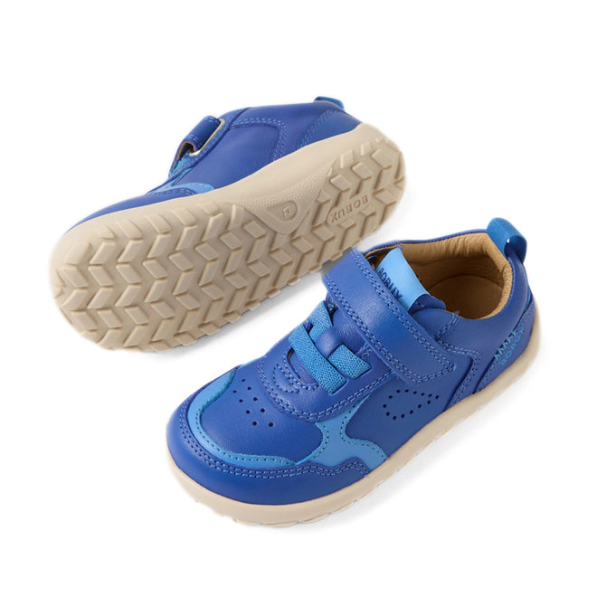 Two Bobux IW Iwalk Neo Toddlers Leather Sneaker Dazzling Blue Barefoot shoes are shown: one stands upright displaying the top and side, while the other is sideways revealing the textured white rubber sole. Both sneakers feature Velcro straps, blue laces, and a barefoot-shaped toebox for comfortable movement., 9420074854551, 9420074854568, 9420074854575, 9420074854582