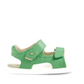 The Bobux IWalk Strand Sandal in Retro Green features adjustable velcro straps, an open toe design, and a white sole, shown from the side against a white background. These leather sandals offer both comfort and easy wear for toddlers’ little feet.