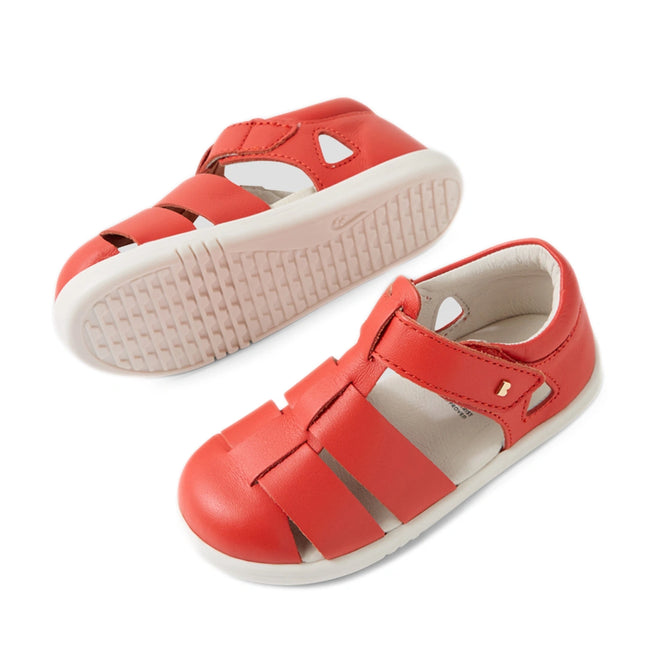 A pair of Bobux IWalk Tidal Sandal Grenadine Red Closed Toe Toddlers is displayed from a side and bottom view against a white background, featuring closed toes, white soles, and velcro straps. These leather sandals are designed to be both stylish and water-friendly for active toddlers., 9420074807755, 9420074807762, 9420074807779, 9420074807786, 9420074807793