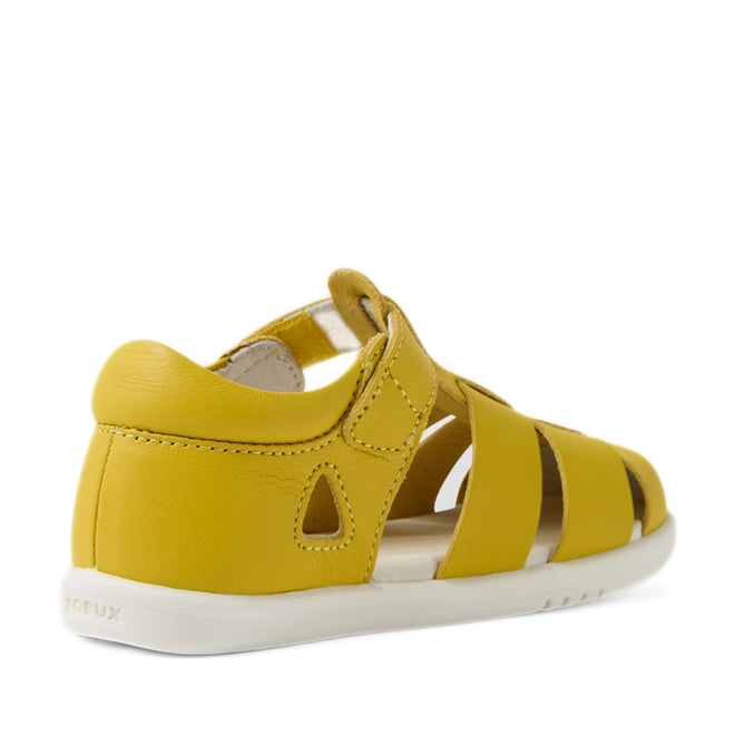 The Bobux IWalk Tidal Sandal Mango Mint Closed Toe Toddlers features a cheerful yellow leather design with a closed heel, open toe, and convenient velcro strap—displayed at an angle from the back and side. With its white sole and cut-out ventilation sections, this sandal is perfect for active children. Made from water-friendly leather, it offers both comfort and durability, making it an ideal choice for summer adventures., 9420074807908, 9420074807915, 9420074807922, 9420074807939, 9420074807946