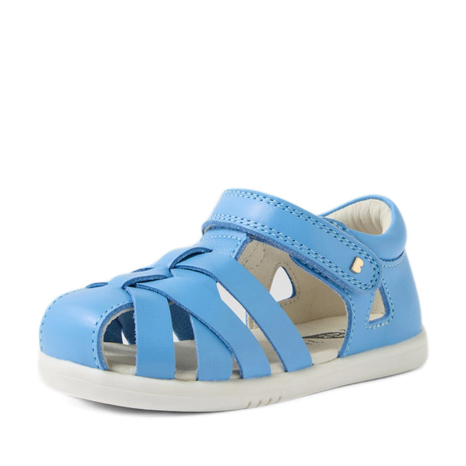The Bobux Iwalk IW Tropicana II Baltic Sea Blue Leather Sandal is a light blue open-toe style for children, inspired by the classic Tropicana design. Featuring multiple straps with a secure hook-and-loop fastening, a white sole, and crafted from leather, these toddler sandals offer small cutout details for added comfort and playful appeal—perfect for little feet., 9420074810250, 9420074810267, 9420074810274, 9420074810281, 9420074810298