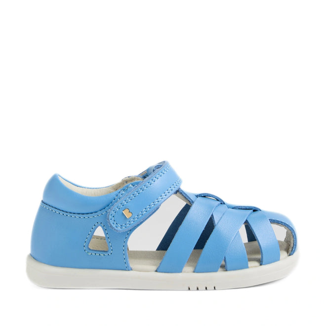 Introducing the Bobux Iwalk IW Tropicana II Baltic Sea Blue Leather Sandal: a toddler’s sandal crafted from premium blue leather, featuring a closed heel, open toe, and white sole. The design offers closed-toe protection with side cut-out details and a Velcro strap—making it an ideal choice for comfortable and secure toddler sandals., 9420074810250, 9420074810267, 9420074810274, 9420074810281, 9420074810298