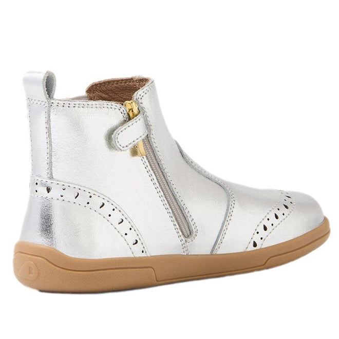 The Bobux Kid+ KP Billie 2 II Girls Leather Boot in silver features shiny leather, a flexible sole, tan rubber base, side zipper, decorative stitching, a small pull tab at the back, and classic brogue details for a comfortable, timeless style., 9420074867032, 9420074867049, 9420074867056, 9420074867063, 9420074867070
