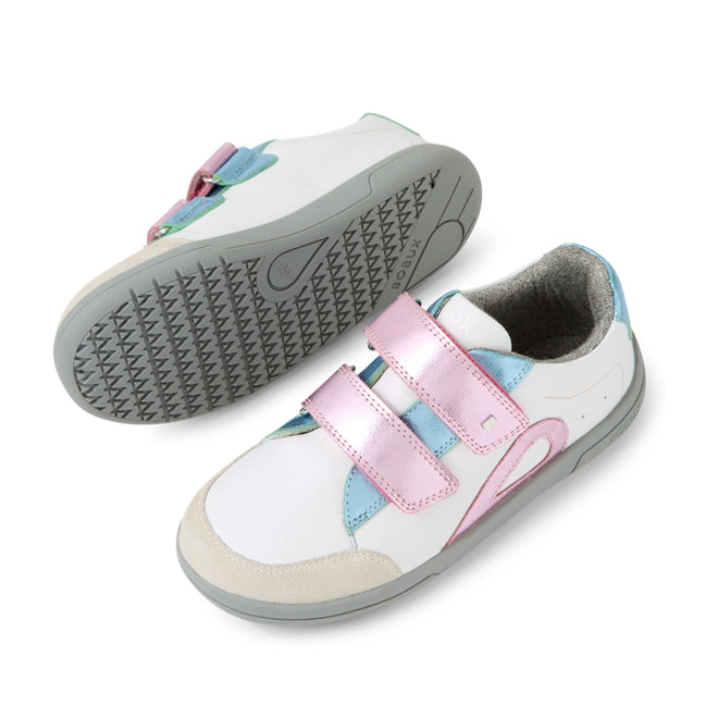 Introducing the Bobux KP Kids Plus Blaze Leather Sneaker in White Pink Metallic: this pair features soft white leather with playful pink, blue, and green accents, plus eye-catching metallic pink Velcro straps. One sneaker is displayed upright while the other lies sideways to showcase its gray textured sole. Designed with a cushioned insole for extra comfort, these sneakers are ideal for active little feet.
