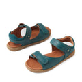 A pair of Mediterranean green open-toed leather sandals with brown insoles and tan soles, the Bobux KP Kids Plus Driftwood Leather Sandal features adjustable Velcro straps at the ankle and across the toes—offering boys a comfortable and stylish option for everyday adventures, inspired by the classic Driftwood Juniors design.