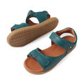 A pair of Bobux KP Kids Plus Driftwood Leather Sandal in Mediterranean Green, featuring tan soles and adjustable Velcro straps, is shown from the side and bottom on a white background., 9420074859013, 9420074858993, 9420074859006, 9420074858979, 9420074858962, 9420074858986, 9420074858955