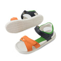 A pair of Bobux KP Kids Plus Dune Leather Sandal Navy for children features navy blue adjustable straps, green lining, and white soles. These breathable summer sandals are crafted for comfort and style—one sandal stands upright while the other lies on its side, showing off the textured sole., 9420074855763, 9420074855787, 9420074855770, 9420074855756