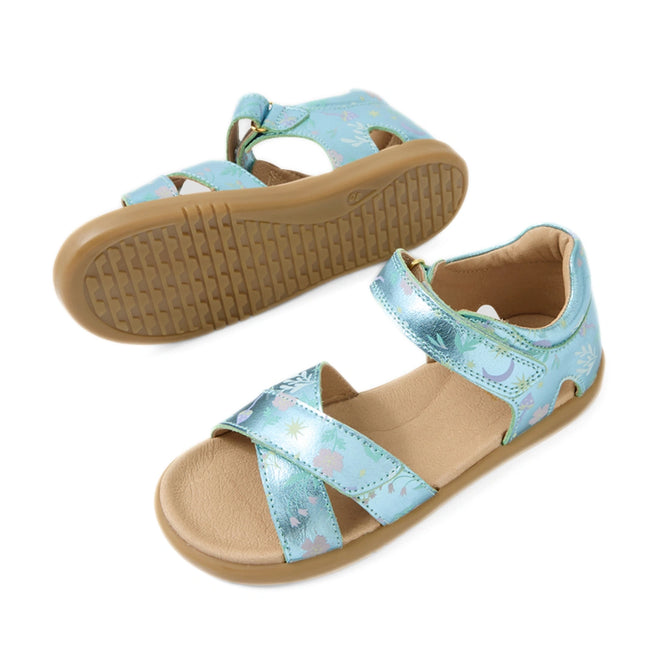 Bobux KP Kids Plus Flora Leather Sandal Jelly Mint Metallic Blue features charming open-toe sandals for children, designed with light blue metallic leather straps, delightful floral patterns, and tan non-slip rubber soles. One sandal stands upright while the other showcases its sole—perfect for little explorers.