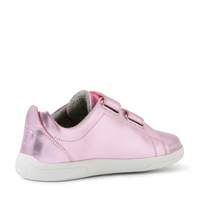 The Bobux KP Kids Plus Grass Court 2 II Leather Sneaker in Pink Metallic features a wide fit, two Velcro straps, gray inner lining, and a white rubber sole. Inspired by the iconic Grass Court design, it is shown from the side and slightly behind on a white background.