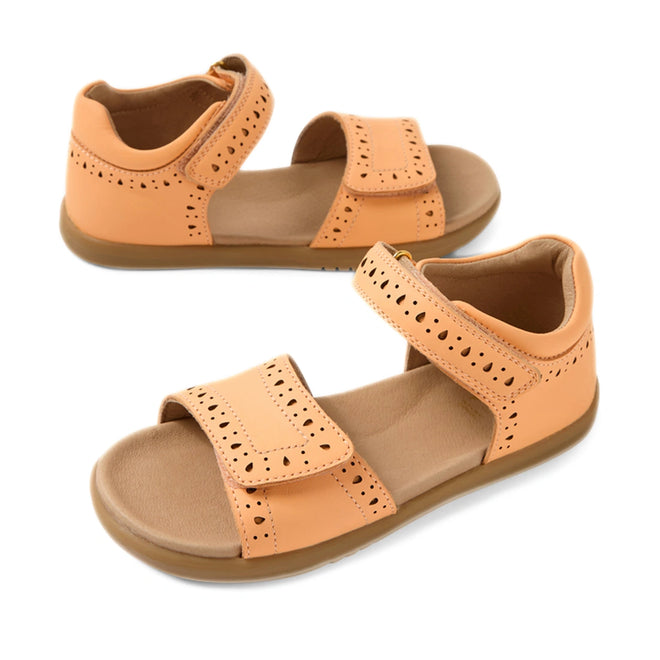 Bobux Kid+ Plus KP Logan Peach Jelly Open Toe Sandal, featuring a tan hue, open-toe design, adjustable Velcro straps, and decorative cutouts crafted from quality leather, is shown from side and top angles against a white background.