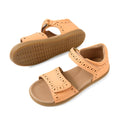 A pair of Bobux Kid+ Plus KP Logan Peach Jelly Open Toe Sandals featuring light brown leather, perforated detailing, adjustable hook-and-loop straps, and rubber soles. One kids’ sandal stands upright while the other lies on its side, displaying the sole’s tread pattern.