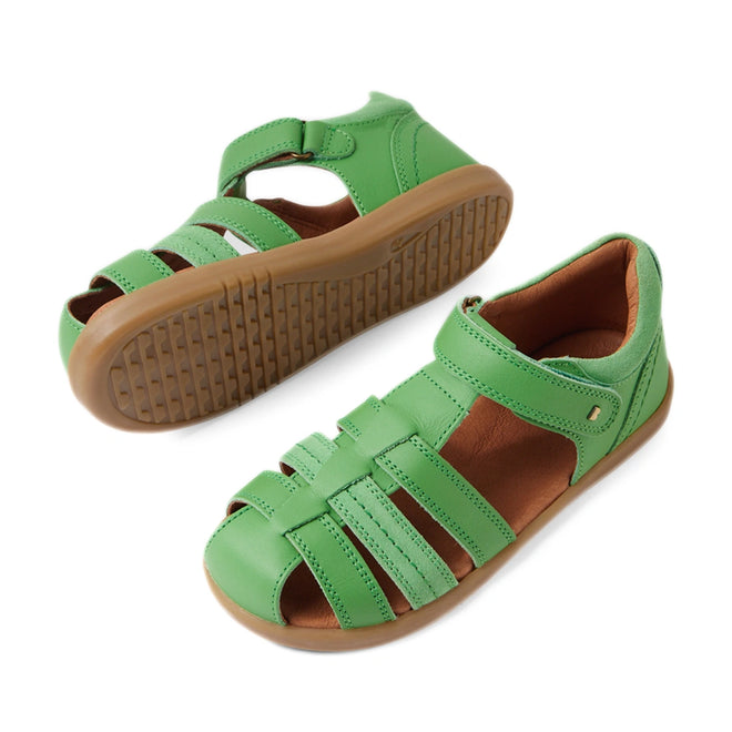 Introducing the Bobux Kid+ Plus Roam Retro Green Closed Toe Sandal—a stylish pair of green leather children’s sandals with tan rubber soles, designed with a closed toe, open sides, and a convenient hook-and-loop ankle strap. These closed-toe leather sandals are perfect for active kids, making them an ideal choice for comfortable and practical summer shoes., 9420074808059, 9420074808028, 9420074808042, 9420074808035