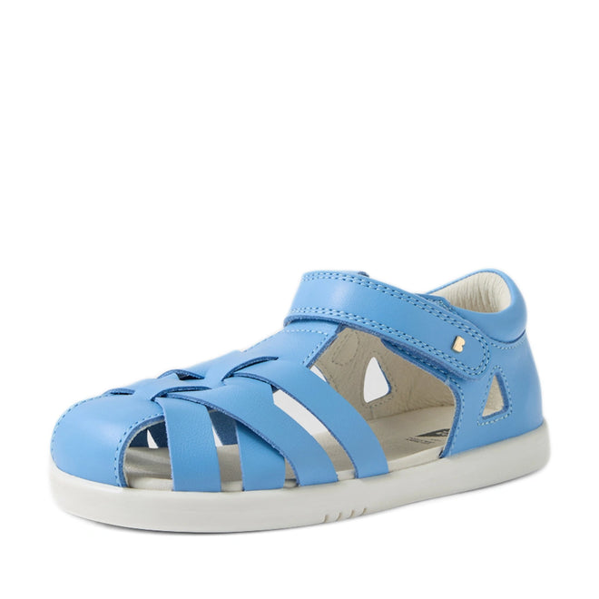 Introducing the Bobux Kids Plus KP Tropicana II Baltic Sea Blue Quick Dry Sandal—a blue closed-toe children’s sandal inspired by the original Bobux Tropicana design. This sandal features a white sole, Velcro strap, and breathable cut-out leather details, making it the perfect quick-dry summer shoe for kids., 9420074861269, 9420074861276, 9420074861283, 9420074861290