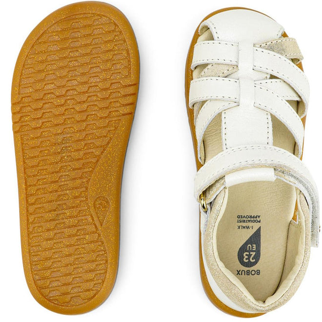The Bobux iwalk Cross Jump Sandal Moon Pearl 636708 is a children’s closed toe sandal in white and beige with a Velcro strap, shown from top and bottom. It features a brown textured sole and comes in size 23 EU., 9420068516335, 9420068516342, 9420068516359, 9420068516366, 9420068516373
