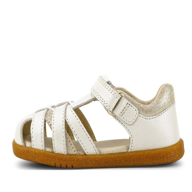 The Bobux iwalk Cross Jump Sandal Moon Pearl Closed Toe 636708 is a small kids' sandal in white leather with a closed heel, open toe, multiple straps, hook-and-loop closure, brown rubber sole, and a gold shimmer on the heel., 9420068516335, 9420068516342, 9420068516359, 9420068516366, 9420068516373