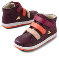 The Bobux KP Kids Plus Juniors Gamepoint Leather Boot in Fig Purple is a children's high-top sneaker with a suede and leather finish, three burgundy, peach, and orange Velcro straps, gold accents, and a rubber sole.