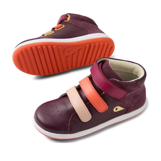 The Bobux KP Kids Plus Juniors Gamepoint Leather Boot in Fig Purple features two children's sneakers with pink and orange adjustable straps, white rubber soles, and orange tread; one shoe is upright, the other shows the sole., 9420074815330, 9420074815347, 9420074815354, 9420074815361, 9420074815378, 9420074815385, 9420074815392