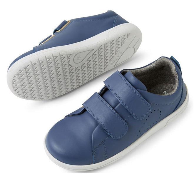The Bobux KP Kids Plus Grass Court II Leather Sneaker in Vintage Indigo Blue features two adjustable straps, white soles, subtle perforations on the sides, and a textured sole, shown with one shoe upright and the other on its side., 9420074859440, 9420074859457, 9420074859464, 9420074859471, 9420074859488, 9420074859495, 9420074859501