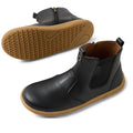 The Bobux KP Kids Plus Jodhpur II Juniors Leather Boot in Black features tan flexible soles, elastic side panels, and a side zipper. One boot stands upright while the other shows its textured sole., 9420074834775, 9420074834812, 9420074834829, 9420074834836