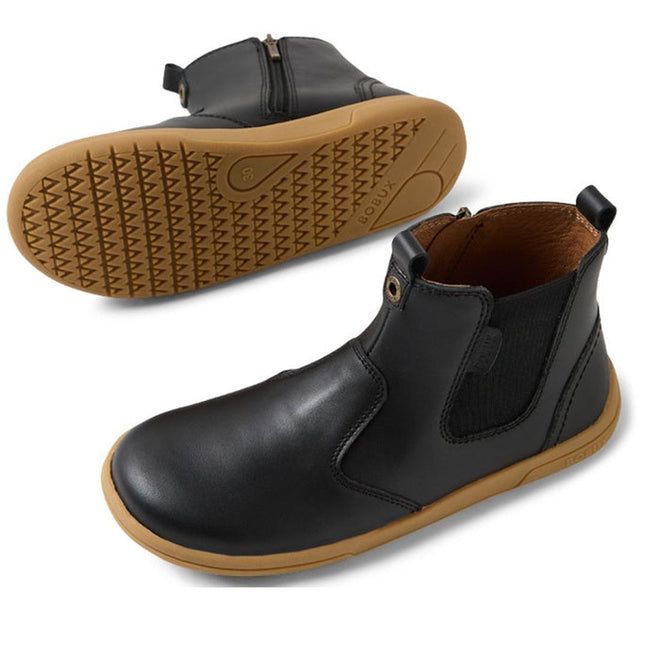 The Bobux KP Kids Plus Jodhpur II Juniors Leather Boot in Black features tan flexible soles, elastic side panels, and a side zipper. One boot stands upright while the other shows its textured sole., 9420074834775, 9420074834812, 9420074834829, 9420074834836