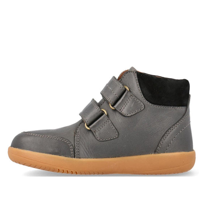 The Bobux Kid+ Timber Boot Charcoal 832924 is a dark gray high-top sneaker with two Velcro straps, tan rubber sole, black padded ankle collar, and visible stitching—perfect as first walkers boots for kids. Shown in side profile on a white background., 9420075797536, 9420075796652, 9420075796669, 9420075796539, 9420075796263, 35618, 35619