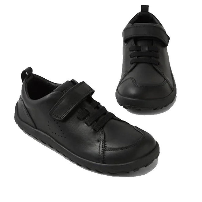 The Bobux Kid+ Prime Alpha Black School Leather Sneaker Shoe for children features a barefoot-shaped toe box, velcro straps, and elastic laces. Shown on a white background: one shoe is side view, the other top-down.