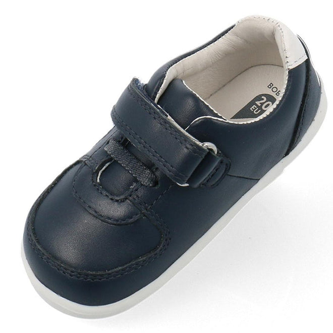 The Bobux Step Up SU Toddlers Leather Sneaker Comet Navy 734603 is a single navy kids sneaker with a hook-and-loop strap, flexible white sole, white inner lining, and visible stitching, shown from above., 9420075706248, 9420075706255, 9420075706262, 9420075706279