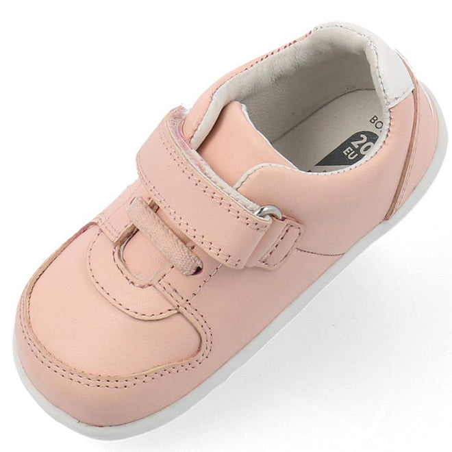 The Bobux Step Up SU Toddlers Leather Sneaker Comet Pink 734604 is shown from an angled top view, featuring a light pink color, hook-and-loop strap, white flexible sole, white inner lining, and visible shoe size on the insole., 9420075706415, 9420075706422, 9420075706439, 9420075706446