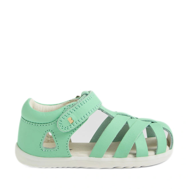 A Bobux Step Up SU Tropicana II Mint Jelly Green Closed Toe Sandal for toddlers, featuring a closed heel, open toe, and white sole. This sandal comes with a hook-and-loop strap and multiple crisscross straps over the foot, providing the comfort and support of premium toddler leather sandals., 9420074809803, 9420074809810, 9420074809827