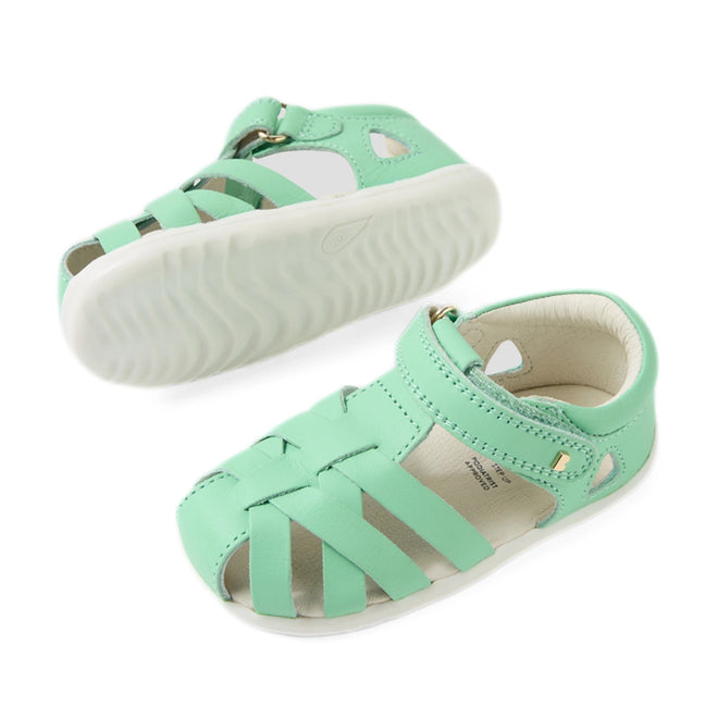 A pair of Bobux Step Up SU Tropicana II Mint Jelly Green Closed Toe Sandals for toddlers, featuring woven leather straps, a closed heel, an open toe, and durable white rubber soles. These stylish sandals include a Velcro closure for easy on and off., 9420074809803, 9420074809810, 9420074809827
