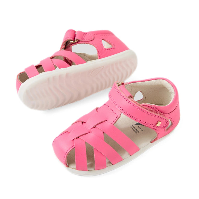 A pair of Bobux Step Up SU Tropicana II Pink Lemonade Closed Toe Sandals, designed for toddlers, featuring a stylish closed heel, woven front straps, a hook-and-loop strap closure, and white soles—perfect closed-toe kids' sandals., 9420074809902, 9420074809919, 9420074809926
