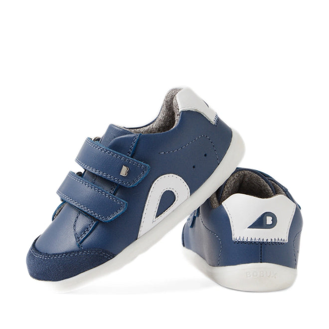 A pair of Bobux SU Step Up Blaze Leather Toddlers Sneakers in Vintage Indigo, featuring blue and white quick-drying leather, soft soles ideal for first walkers, velcro straps, and a small B logo on the heel—one shoe displayed facing forward and the other showing the back.