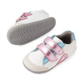 Featured here are two Bobux SU Step Up Blaze Leather Toddlers Sneakers in White Pink, designed for first walkers. Each kids’ leather sneaker boasts pink, blue, and teal accents, a gray rubber sole, and two metallic pink hook-and-loop straps. One shoe is upright while the other is on its side to display the sole., 9420074848833, 9420074848840, 9420074848857, 9420074848864