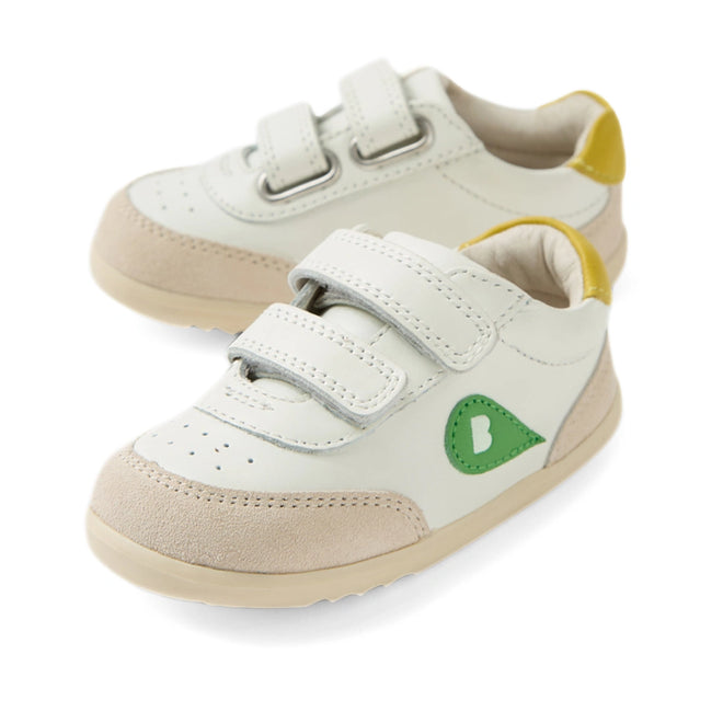 The Bobux Step Up SU Champ Sneaker First Walker in White Green is a pair of small white toddler shoes featuring beige soles, light tan suede accents, a green side logo, yellow heel detail, and two hook-and-loop straps each—these comfy kids’ leather sneakers make perfect first walkers for your little one.