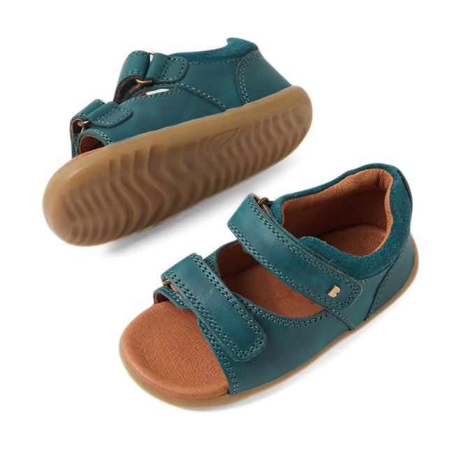 A pair of Bobux SU Step Up Driftwood First Walker Open Toe Sandal Mediterranean Green children’s sandals, featuring brown rubber soles, open toes, and two adjustable Velcro straps—perfect as first walking shoes—displayed on a white background., 9420074807458, 9420074807465, 9420074807472