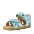 The Bobux Step Up Flora First Walker Jelly Mint Metallic Blue is a light blue sandal featuring floral prints, metallic blue accents, a tan sole, and adjustable Velcro straps on the front and ankle for easy fitting—perfect leather sandals for toddlers taking their first steps.