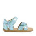 The Bobux Step Up Flora First Walker Jelly Mint Metallic Blue is a child’s sandal with a metallic blue upper adorned with colorful floral patterns, two adjustable hook-and-loop straps, and a tan rubber sole.