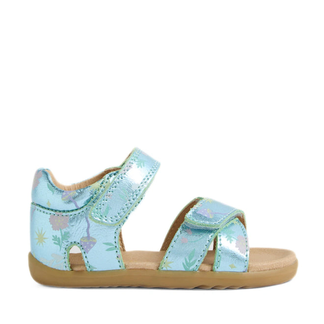 The Bobux Step Up Flora First Walker Jelly Mint Metallic Blue is a child’s sandal with a metallic blue upper adorned with colorful floral patterns, two adjustable hook-and-loop straps, and a tan rubber sole.