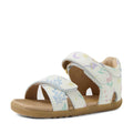The Bobux Step Up Flora First Walker Sandal in White Floral features soft white leather straps decorated with a delicate floral and star print, an open toe design, and a tan rubber sole—making it the perfect first walking leather sandal for your little one.