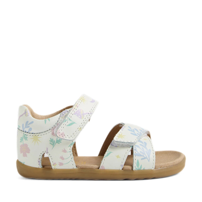 The Bobux Step Up Flora First Walker Sandal White Floral is a children’s sandal crafted from white leather with pastel floral patterns. Designed for early steps, it features hook-and-loop ankle and toe straps for a secure fit, an open toe, and a tan sole. The sandals are displayed in profile against a plain white background.